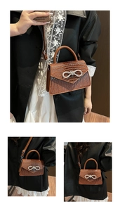 Detail of brown crocodile pattern handbag with sparkling rhinestone bow buckle