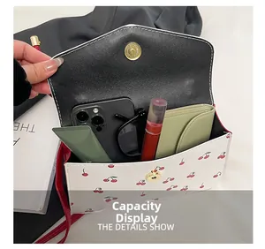 Internal view of cherry print white square bag showing capacity for phone and cosmetics