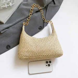 Gedetailleerde vergelijking van de beige stro schoudertas met luxe gouden kettingriem