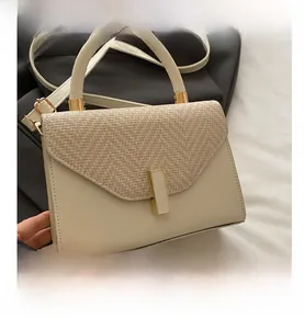 Detailed view of the cream retro handbag featuring woven flap and gold hardware lock