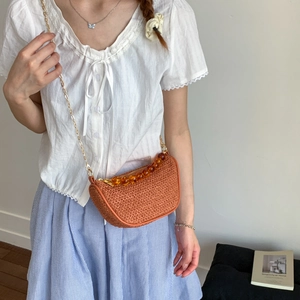 Orange half-moon straw crossbody bag with amber beads and gold chain strap for women