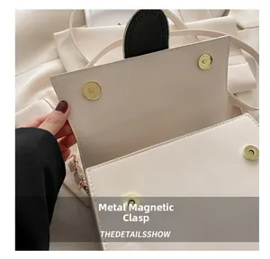 Détail du sac à bandoulière crème minimaliste avec quatre fermoirs magnétiques dorés