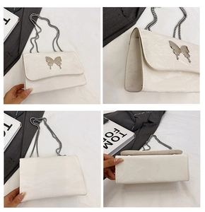 Détails du sac blanc à texture marbrée avec fermoir papillon argenté et bandoulière chaîne