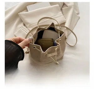 Top view showing the large interior capacity of the beige drawstring bucket bag with essentials