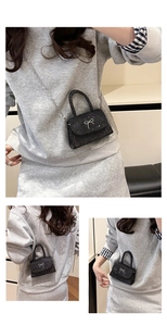 Detail of black sequin mini bag with silver bow decoration and metallic chain strap