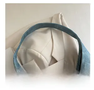Detail of wide integrated handle on blue denim tote bag with high-quality fabric texture