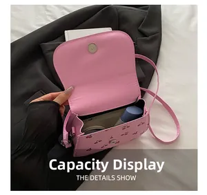 Detail showing the magnetic snap closure and interior capacity of the cherry print bag
