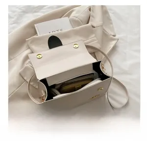 Détail de l'intérieur du sac beige montrant sa grande capacité et son fermoir magnétique