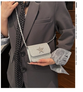 Détail du mini sac argenté scintillant avec boucle étoile en strass porté à l'épaule
