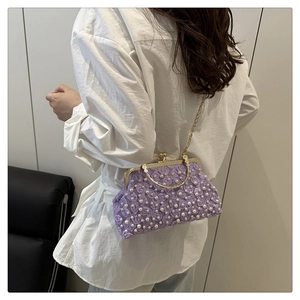 Détail du sac de soirée violet avec fleurs en 3D et accents de perles blanches