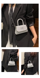 Detailed view of silver rhinestone mini bag with bow accent and chain shoulder strap