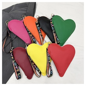 Nahaufnahme herzförmiger Handtaschen in mehreren Farben mit bunten LOVE-Handschlaufen