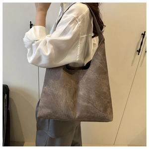 Detail of a vintage washed tote bag with vertical stitching and wide shoulder strap
