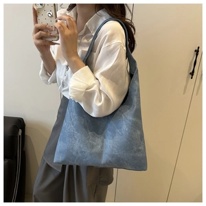 Detail of blue washed canvas tote bag with vintage texture and wide shoulder strap