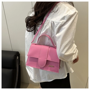 Vue latérale du sac à bandoulière rose vif avec poignée et logo en métal doré