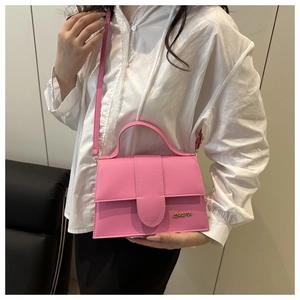 Bolso bandolera rosa de cuero sintético con asa superior mostrado en una modelo