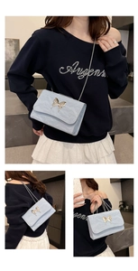Détail du sac bandoulière bleu clair avec boucle papillon argentée et chaîne métallique