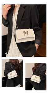 Vue détaillée du sac bandoulière crème avec texture nuage et boucle papillon argentée