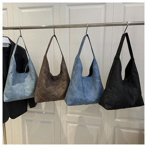 Four colorful vintage washed tote bags hanging on a rack showing capacity and texture