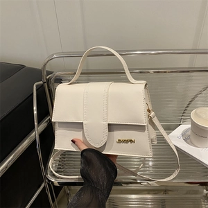 Sac à main beige structuré avec logo doré et bandoulière longue style minimaliste