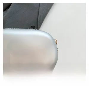 Gros plan détaillé sur le métal argenté mat texturé de ce sac pochette moderne