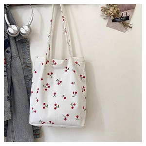 Dettaglio della borsa tote in velluto a coste bianco con stampe di ciliegie e spalline lunghe