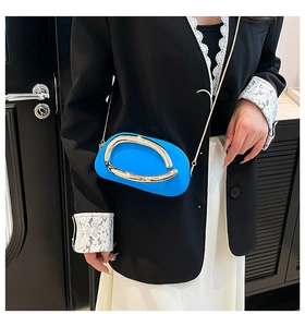 Détail du mini sac bleu avec une grande boucle dorée ovale et une fine bandoulière