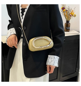 Détail d'un sac bandoulière jaune avec boucle en métal argenté et bandoulière chaîne sur modèle