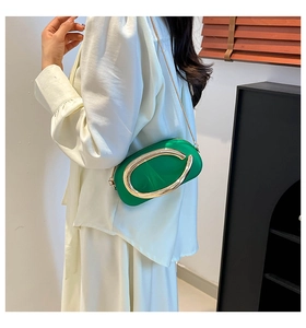 Détail du sac capsule vert émeraude avec ornement anneau en métal doré audacieux