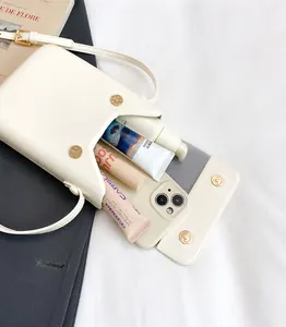 Detalle del interior de un bolso bandolera crema con espacio para móvil y cosméticos