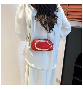 Détail du sac bandoulière ovale rouge avec grand anneau doré et chaîne fine