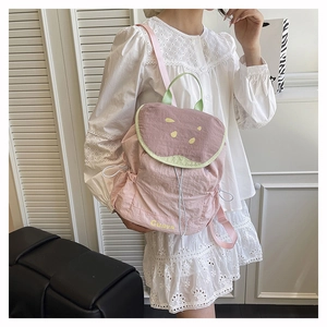 Dettaglio di uno zaino rosa a tema guava con accenti verdi e coulisse bianca di chiusura