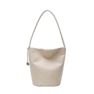 Minimalistische beige emmertas van generfd leer met zilveren kettinghanger decoratie
