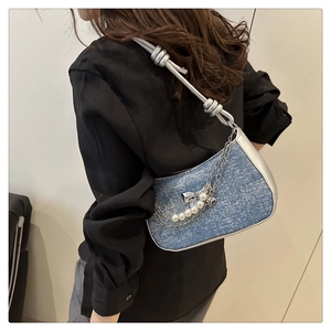 Détail du sac d'épaule en denim avec garniture argentée et chaîne papillon perle