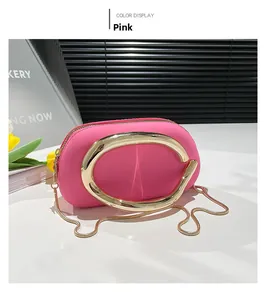 Détail de la pochette en acrylique rose avec poignée ovale dorée et chaîne serpent