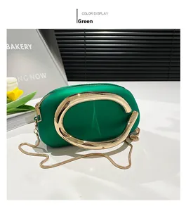 Détail du sac de soirée en acrylique vert avec grande poignée en métal doré