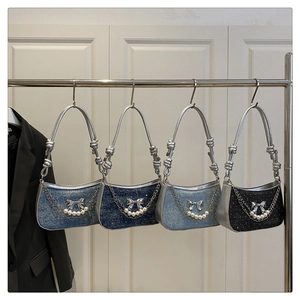 Detail of four butterfly-themed shoulder bags in denim and black sequin with pearl chains