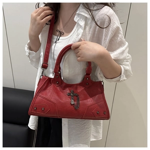 Detail of red locomotive bag featuring vintage silver cross pendants and metal studs