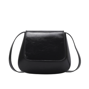 Glossy black leather saddle bag for women with minimalist flap and slim strap