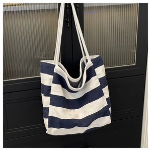 Detailweergave van de dikke kepertextuur op een blauw-wit gestreepte canvas shopper tas