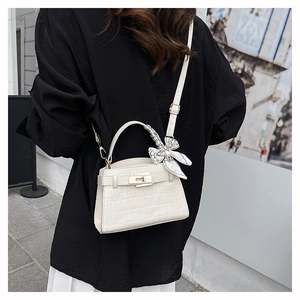 Detail of white crocodile pattern square bag with gold lock and printed handle scarf