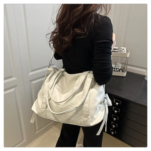 Détail du sac cabas crème avec texture litchi et bandoulière réglable