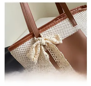 Close-up of woven straw tote bag with lace bow detail and brown leather handle