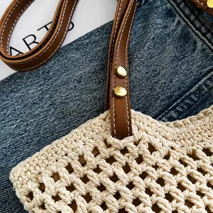 Nahaufnahme der beigen Häkeltasche mit braunem Ledergriff und goldenen Metalldetails