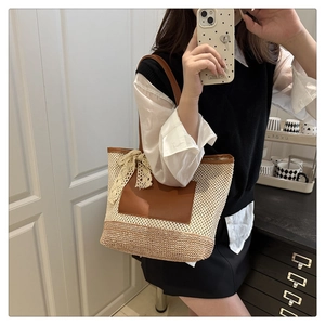 Detail of woven straw tote bag featuring leather pocket and beige lace bow decoration
