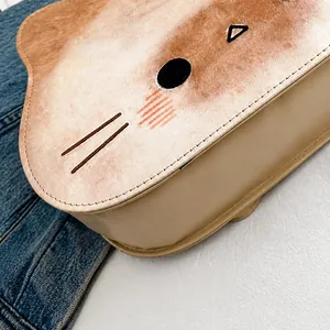 Detailansicht der Präzisionsnaht und Katzenmuster auf der beigen PU-Tragetasche