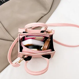 Detail showing the internal storage capacity of the pink mini crossbody bag