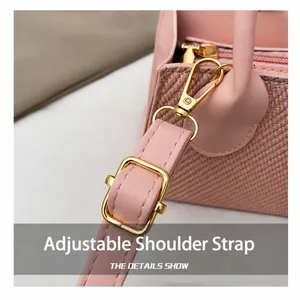 Close-up of adjustable pink leather shoulder strap with gold metal hardware on bag