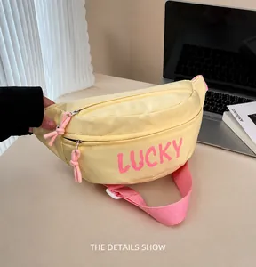 Detail view of a yellow nylon sports fanny pack with pink LUCKY text and adjustable strap