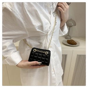 Detail van een mini gewatteerde crossbodytas van zwart PU-leer met een gouden ketting